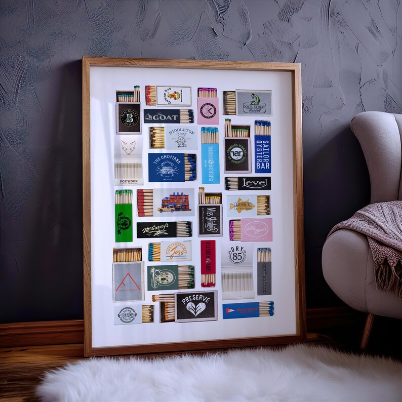 May include: A framed collage of matchboxes with various designs and logos. The matchboxes are arranged in a grid pattern and feature a variety of colors, including red, blue, green, and yellow. Some of the logos include "GOAT", "The Chophouse", "Sailor Oyster Bar", and "Level".