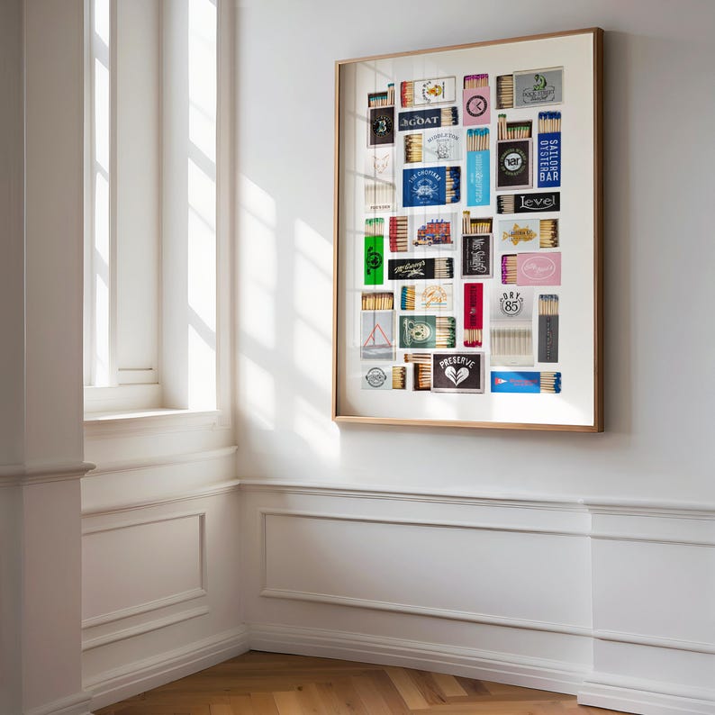 May include: A framed collage of matchbox labels, featuring a variety of designs and colors. The labels are arranged in a grid pattern, and some of them include text such as "GOAT", "PRESERVE", and "DRY 85".