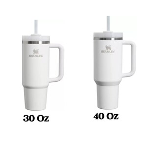 Peut inclure: Deux mugs de voyage Stanley blancs avec couvercles et pailles. Le mug de gauche est de 30 oz et le mug de droite est de 40 oz.