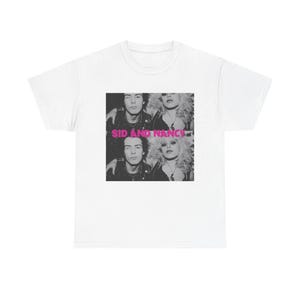 Könnte beinhalten: Weißes T-Shirt mit einem Schwarz-Weiß-Bild von zwei Personen und dem rosa Text "SID AND NANCY". Das Bild ist eine Nahaufnahme der beiden Personen, wobei der Text fett und ohne Serifen ist.