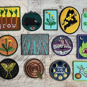 Peut inclure: Un ensemble de 12 patchs brod&eacute;s thermocollants aux motifs inspir&eacute;s de la nature. Les patchs comprennent un pissenlit, une for&ecirc;t, une cha&icirc;ne de montagnes, une lune, un v&eacute;lo, un bocal de foug&egrave;res, une ruche, un papillon de nuit, une souche d'arbre, une sc&egrave;ne de camping et un champ de carottes avec le mot "grow".