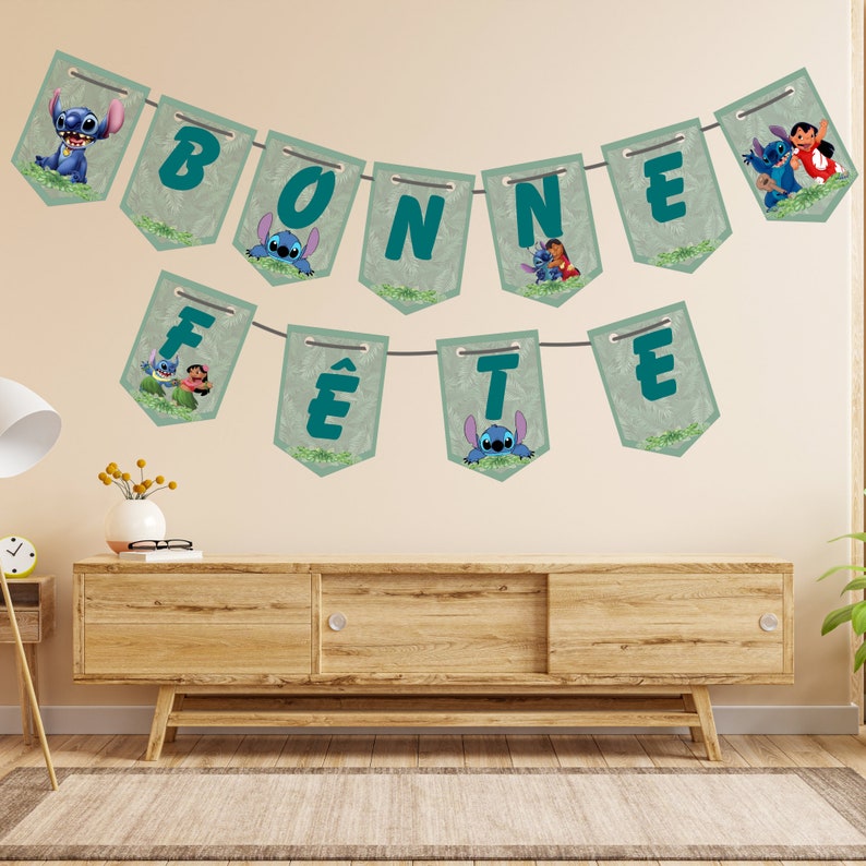 May include: A green and blue banner with the words "BONNE F&Ecirc;TE" and images of Stitch and Angel from the Disney movie Lilo & Stitch.