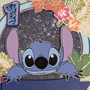 May include: A blue and purple Stitch character from the Disney movie Lilo & Stitch peeks over a blue banner with a glittery blue number one on a dark blue background with glitter. The background is decorated with green and orange tropical leaves and flowers.