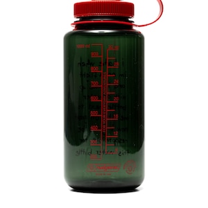 May include: A dark green water bottle with a red cap and handle. The bottle has a clear, graduated scale in red, marked in milliliters and ounces. The text "FOR YOUR EVERYDAY ADVENTURES" is printed on the side. The bottle is made by Nalgene.