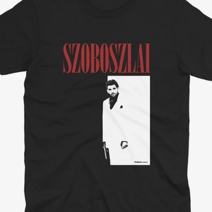 K&ouml;nnte beinhalten: Schwarzes T-Shirt mit einer roten Grafik eines Mannes im wei&szlig;en Anzug und dem Text "SZOBOSZLAI".