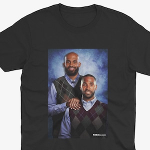 May include: A black t-shirt with a photo of two men wearing sweaters. The men are standing in front of a blue and white background. The text "Putback Classics" is at the bottom of the photo.