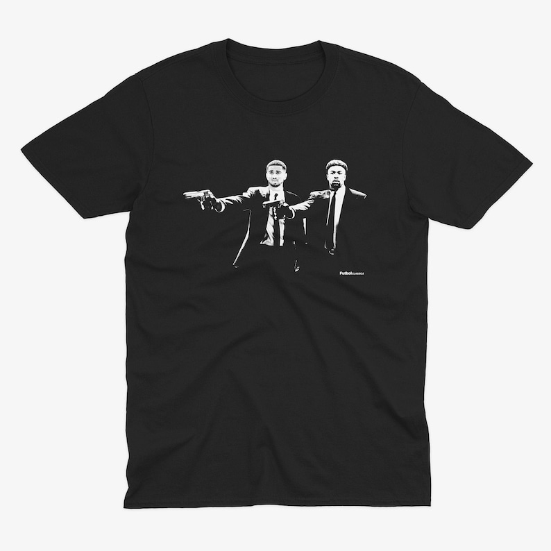 May include: Black t-shirt with a white silhouette of two men in suits holding guns. The text "Pulp Fiction" is printed below the image.