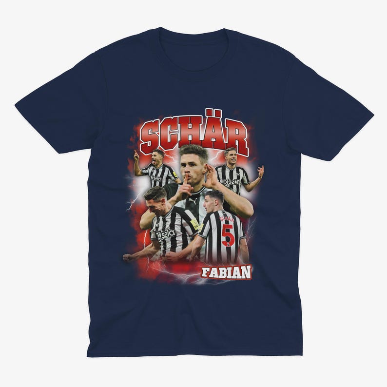 May include: A navy blue t-shirt featuring a retro-style graphic of a football player, Fabian Sch&auml;r, wearing a black and white jersey with the number 5. The graphic is surrounded by red lightning bolts and the text "Fabian" and "Sch&auml;r" in red.