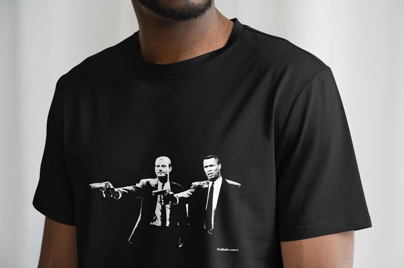 May include: Black t-shirt with a white graphic print of two men in suits holding guns. The text "Pulp Fiction" is printed at the bottom of the graphic.
