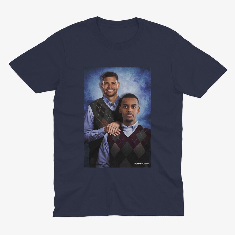 May include: A navy blue t-shirt featuring a photograph of two men wearing sweaters. The men are standing in front of a blue and white background. The text "Fullback Classics" is printed at the bottom of the photograph.