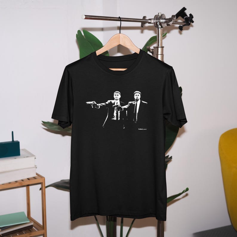 May include: Black t-shirt with a white graphic of two men in suits pointing guns. The graphic is a scene from the movie Pulp Fiction.
