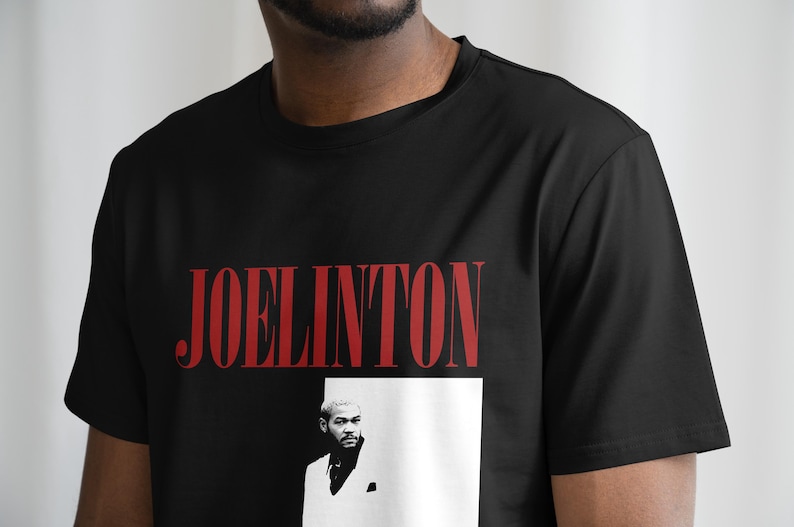 Pode incluir: Camiseta preta com texto vermelho que diz "JOELINGTON" e uma foto em preto e branco de um homem de terno.