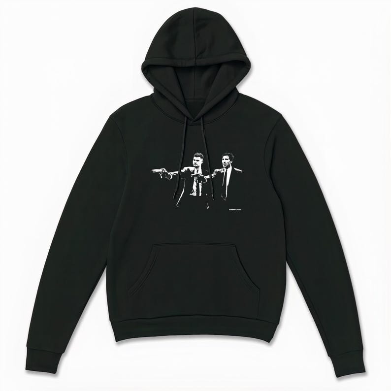 May include: Black hooded sweatshirt featuring a white graphic of two men in suits pointing guns. The sweatshirt has a front pocket and a drawstring hood. The graphic is a stylized illustration.