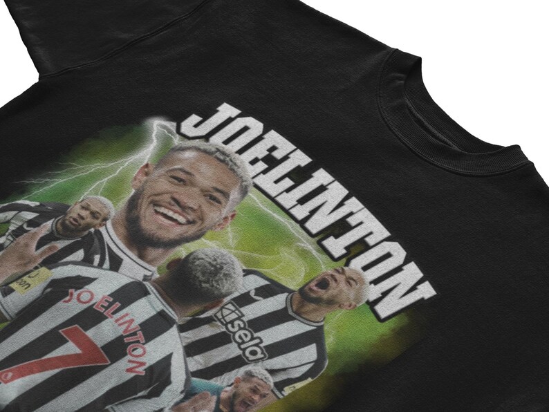 Pode incluir: Camiseta preta com um gr&aacute;fico de um jogador de futebol em um uniforme preto e branco. O nome do jogador, "Joelinton", est&aacute; escrito em letras brancas na parte superior da camiseta.