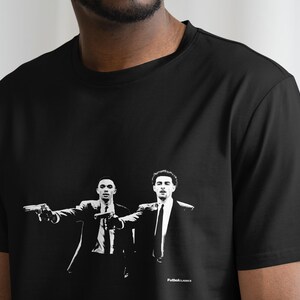 May include: Black t-shirt with a white graphic print of two men in suits holding guns. The text "Pulp Fiction" is printed on the bottom of the shirt.