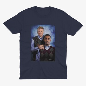 May include: A navy blue t-shirt with a photo of two men wearing sweaters. The man on the left is wearing a blue and white patterned sweater and the man on the right is wearing a red and white patterned sweater. The text "FullHouseClassics" is printed on the bottom right corner of the image.