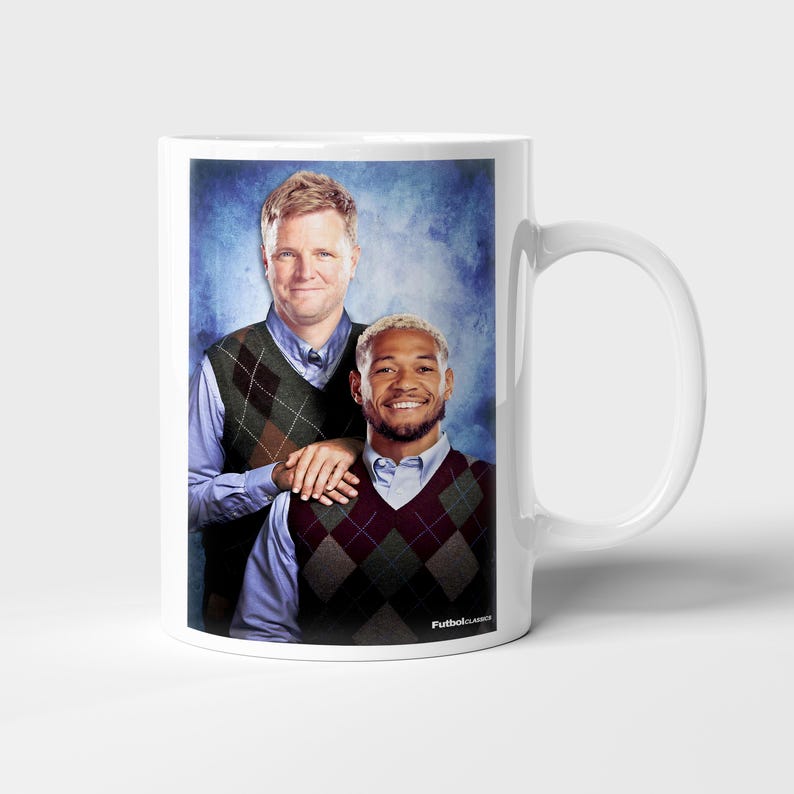 May include: White ceramic mug featuring a printed image of two men wearing argyle vests over button-down shirts. The image has a blue background and the text "FutbolClassics" is printed on the mug.