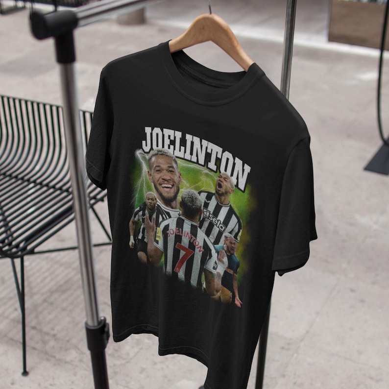 Pode incluir: Camiseta preta com uma estampa gr&aacute;fica de um jogador de futebol, Joelinton, com um uniforme preto e branco. O texto "JOELINGTON" est&aacute; impresso em letras brancas na camiseta.