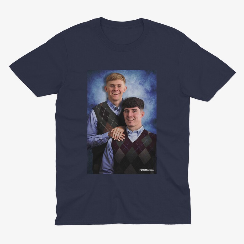 Pu&ograve; includere: Una t-shirt blu navy con una foto di due persone che indossano maglioni. La foto &egrave; su uno sfondo blu e bianco. Il testo "Puttin' on Classics" &egrave; in basso nella foto.