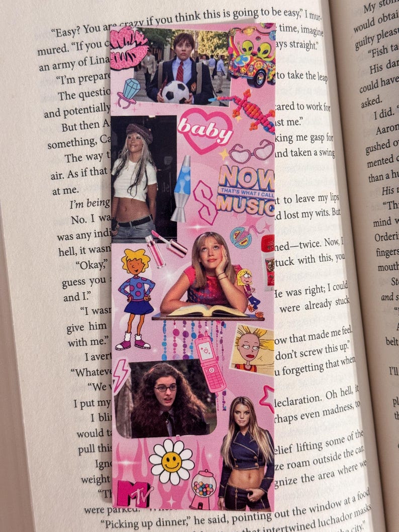 May include: Pink bookmark with various images and text, including a baby graphic, a lava lamp, and the words "NOW THAT'S WHAT I CALL MUSIC." The bookmark features images of celebrities and cartoon characters.
