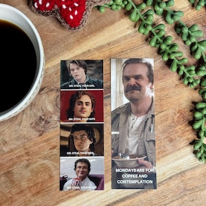 May include: A wooden cutting board with a cup of coffee, a crocheted red and black flower, and a sprig of green faux succulents. There are four small rectangular images with the text "MR. STEAL YOUR GIRL", "MR. STEAL YOUR WIFE", "MR. STEAL YOUR KIDS", and "MR. STEAL YOUR HEART". A bookmark with the text "MONDAYS ARE FOR COFFEE AND CONTEMPLATION" is also present.