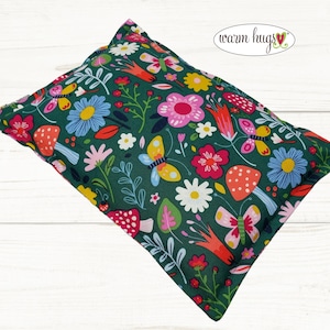 May include: A green fabric pillow with a colorful floral and butterfly print. The pillow has the text "warm hugs" on it.
