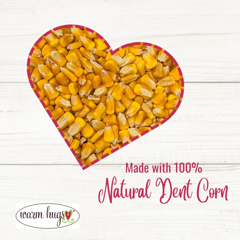 May include: A heart-shaped arrangement of yellow dent corn kernels on a white wooden background. The text "Made with 100% Natural Dent Corn" is below the heart. The text "warm hugs" is in the bottom left corner with a small red heart.