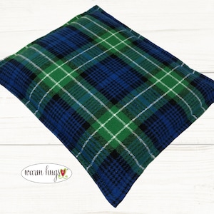May include: A blue and green plaid fabric heating pad. The pad is rectangular and has a soft, plush texture.