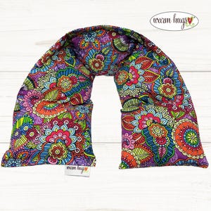 May include: A colorful paisley patterned neck wrap with a "warm hugs" logo. The neck wrap is made of fabric and is designed to be heated.