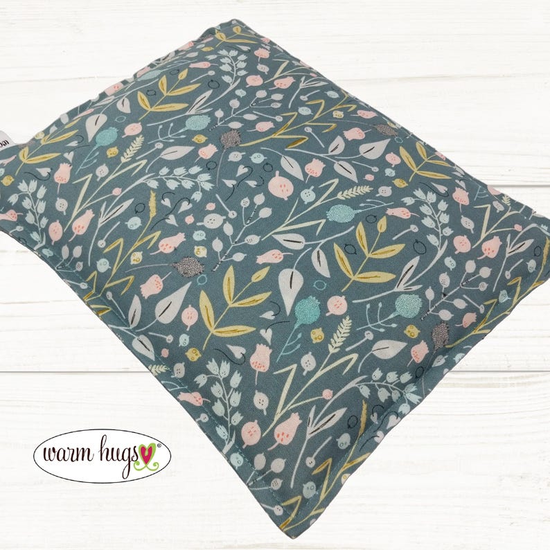 May include: A teal blue fabric pillow with a floral pattern in shades of pink, yellow, and white. The pillow is made of soft, comfortable fabric and is perfect for cuddling up on the couch.