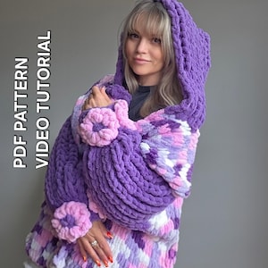 May include: A chunky, hooded cardigan made of thick, purple, pink, and white variegated yarn. The garment features large, textured, circular floral appliques on the sleeves and includes the text PDF PATTERN VIDEO TUTORIAL on the left side.