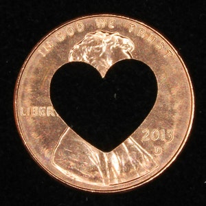 Centavo de la suerte con corazón recortado