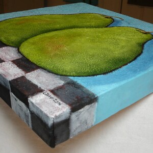 May include: A square canvas painting featuring two green pears on a light blue background. The painting has a checkerboard pattern on the left side, with a signature in the corner. The pears have a textured appearance.