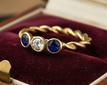 Vintage ring van 14 karaats goud met diamanten en saffieren, met een gedraaide touwband.