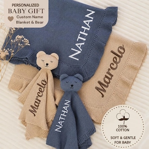 May include: A personalised baby gift set with two knitted blankets and two bear security blankets. The blankets are navy blue and tan, embroidered with the names "Nathan" and "Marcelo". The bear security blankets match the colours of the blankets.