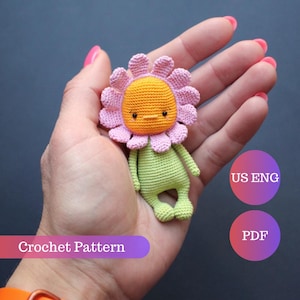 May include: A handmade crochet flower doll with a pink and orange flower head, green body, and small arms and legs. The doll is held in a hand. The text "Crochet Pattern" is displayed.