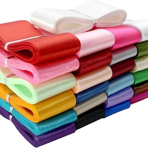May include: A stack of 15 satin ribbon rolls in various colors, including red, pink, green, blue, and white. The ribbons are arranged in a fan shape, with the white ribbon at the top.