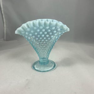 May include: A light blue glass vase with a ruffled top and a textured, bubbled surface.