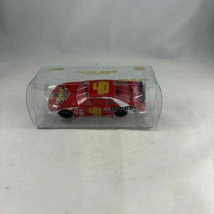 Könnte beinhalten: Ein rotes Spielzeug-Rennauto mit der Nummer 40 auf dem Dach und den Seiten, präsentiert in einer transparenten Kunststoffbox. Das Auto hat weiße und gelbe Akzente, und das Wort "Charlotte" ist sichtbar. Die Box trägt den Text "Coca-Cola 600 Program Car May 30, 1999."