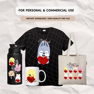 K&ouml;nnte beinhalten: Ein Set Stray Kids Merchandise mit einem schwarzen T-Shirt, einer Tragetasche, einer Wasserflasche und einer Tasse. Die Designs zeigen einen Cartoon-Wolf, der ein Herz h&auml;lt, und andere Cartoon-Tiere mit Herzen.