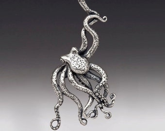 May include: A silver octopus pendant necklace with a textured finish. The octopus has eight tentacles and is in a curled position.