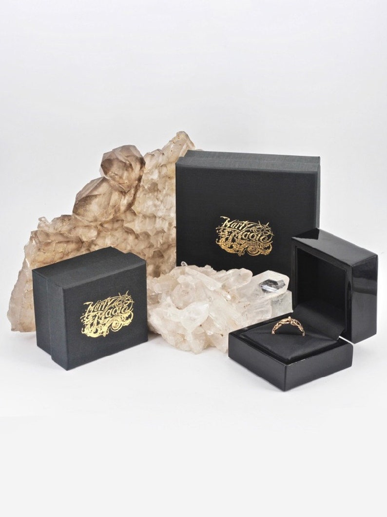 May include: Two black boxes with gold lettering that reads "Harry Hardie" and a smaller black box with a gold ring inside.