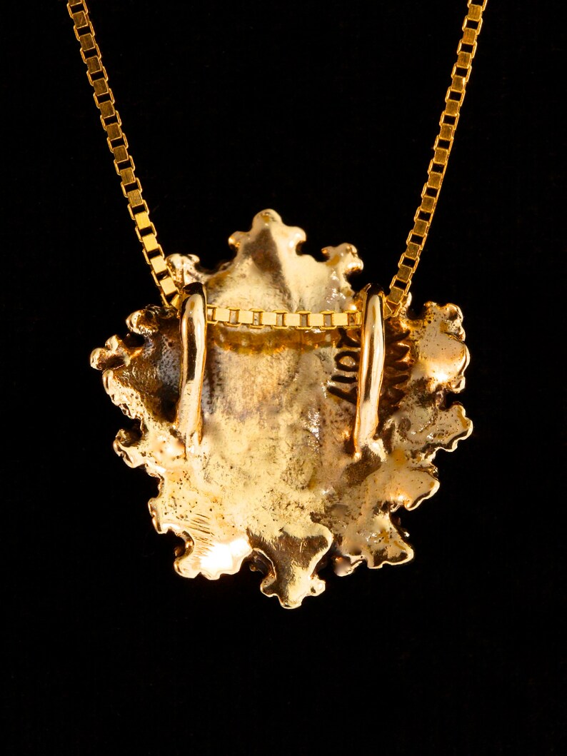 Pu&ograve; includere: Collana con ciondolo in oro, dal design ornato e dettagliato. Il ciondolo ha la forma di un cuore e presenta una superficie testurizzata. La collana &egrave; realizzata con una catena delicata.