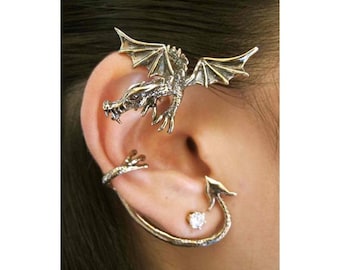 May include: Silver dragon ear cuff with a curled tail and a dragon head with wings. The ear cuff is worn on the upper part of the ear.