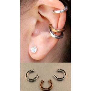 May include: Three silver horseshoe ear cuffs, one gold horseshoe ear cuff, and a single silver stud earring with a clear stone.
