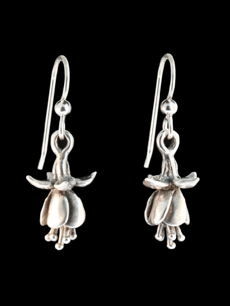 May include: A pair of silver dangle earrings featuring a detailed fuchsia flower design.
