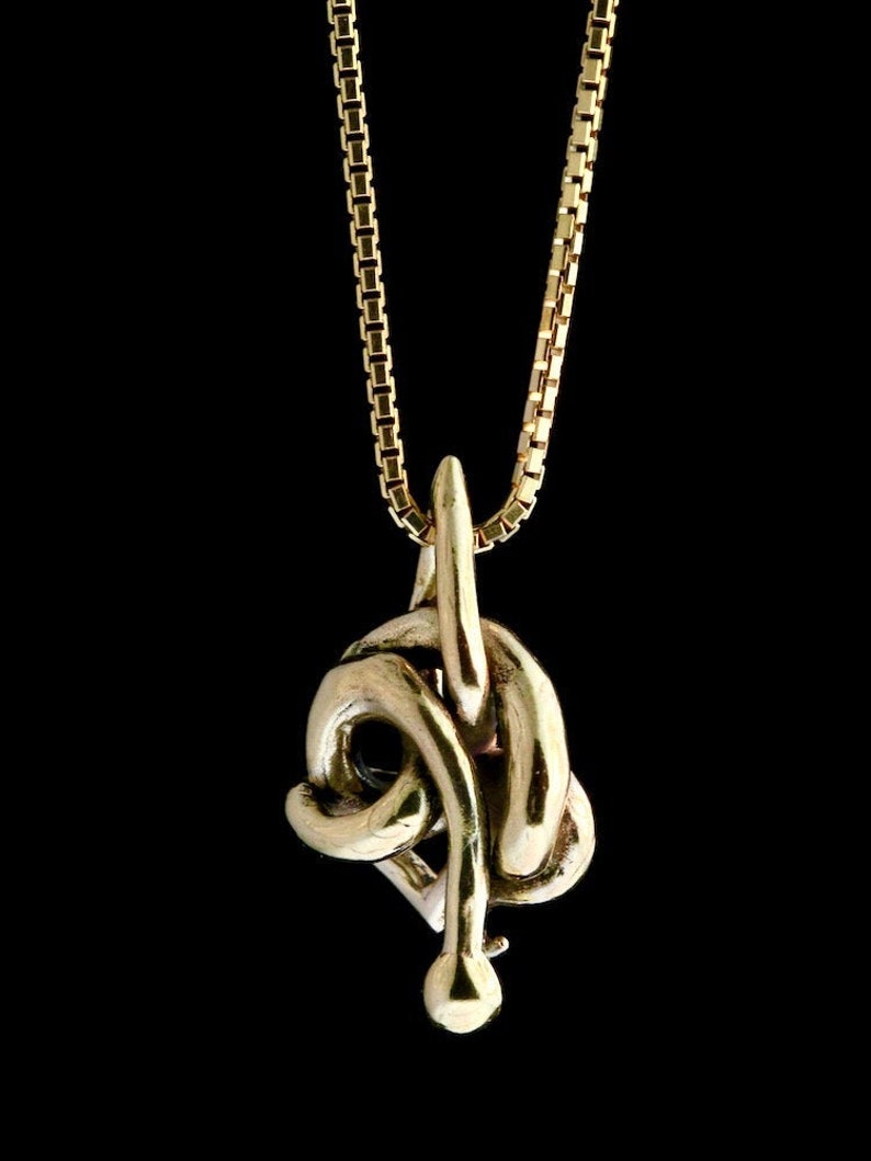 May include: A gold chain necklace with a pendant shaped like a snake knot. The snake is curled up in a knot, with its tail pointing up.