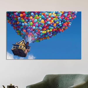 Könnte beinhalten: Ein gelbes Haus mit rotem Dach ist an einem Bündel bunter Ballons befestigt und schwebt in einem blauen Himmel. Das Haus hat Fenster und eine Tür, und im Hintergrund sind Bäume zu sehen.