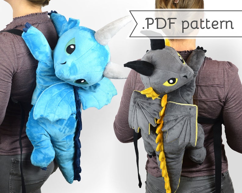 May include: Two people wearing plush dragon backpacks. One dragon is blue with yellow accents and the other is gray with yellow accents. The text '.PDF pattern' is visible in the image.