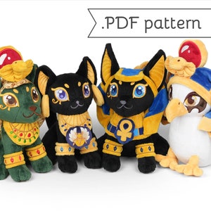 May include: Four plush toys inspired by Egyptian mythology. The toys are a green Anubis, a black Bastet, a yellow Anubis, and a white Bastet. Each toy has a gold collar and a headdress.
